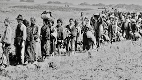 移民の行列を歩く人々の白黒写真