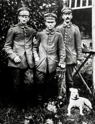 軍服を着た3人の男性と犬が立っている白黒の写真