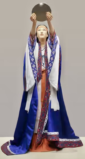 青いローブを着た女性が、円盤を掲げている像